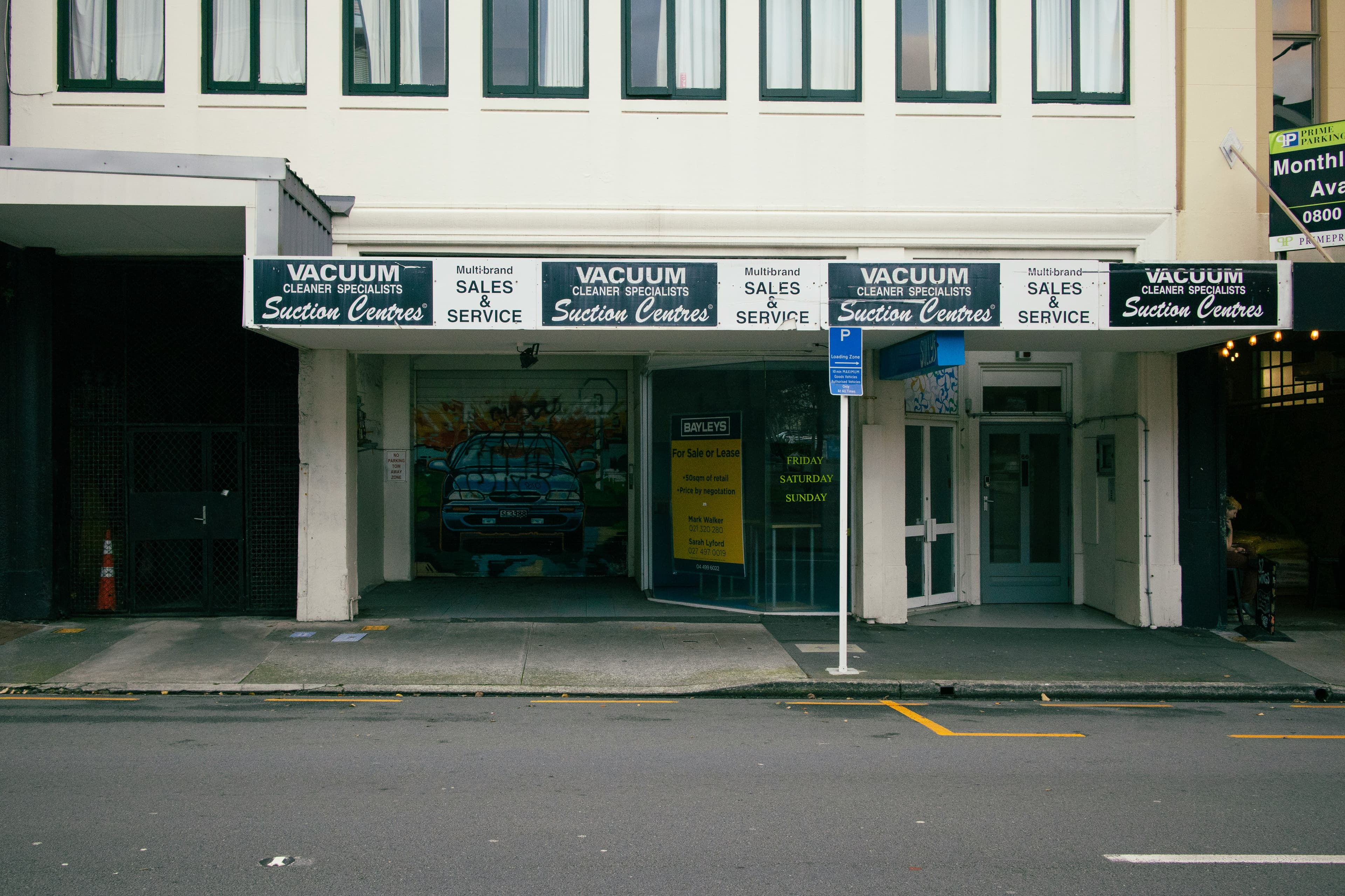 Street view of a shop with signage for sales and services.